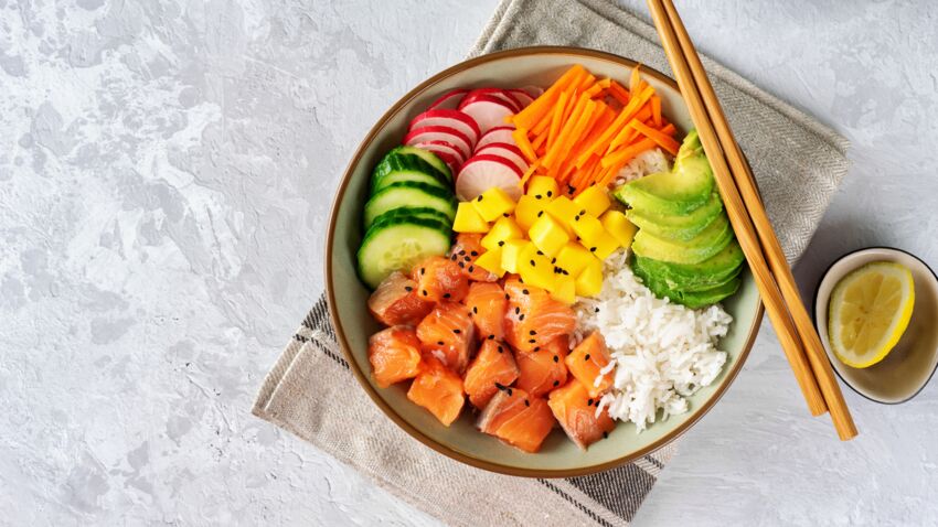 Top view of poke bowl with vegetables, rice and salmon